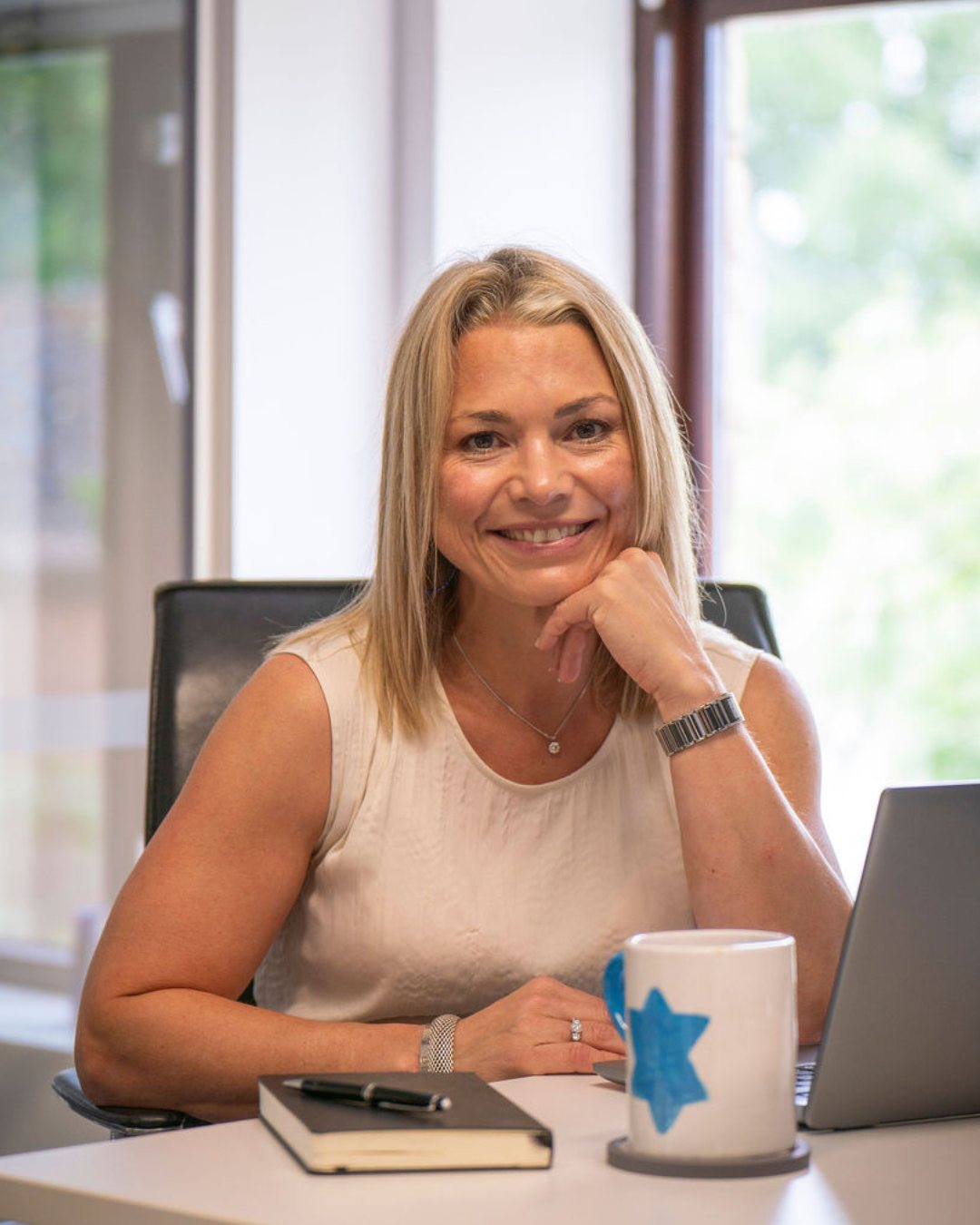 Charley Southon at her desk, laptop and notebook in front of her